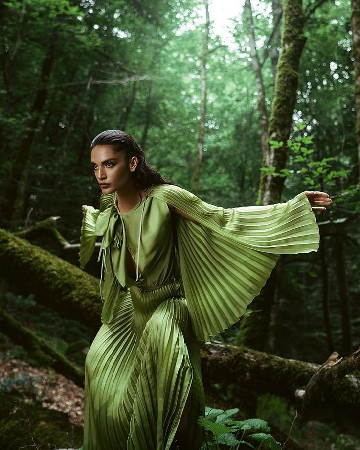 Femme portant une robe fluide verte plissée dans la forêt, Collection Forêt d’Émeraude Etikashion.